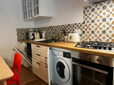 a kitchen with a stove and a washing machine at MaisonAdèle in Caromb