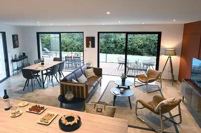 a living room with a couch and a table at La Villa Plein Soleil in LʼIsle-sur-la-Sorgue