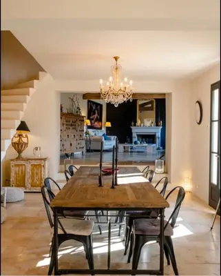 a dining room with a wooden table and chairs at Mas des Gémeaux in Ménerbes