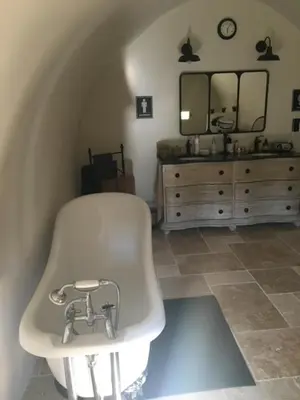 a bathroom with a tub and a sink and a mirror at Mas des Gémeaux in Ménerbes