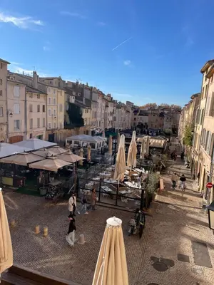 a group of umbrellas and tables on a city street at Studio climatisé plein centre ville 2ème ETAGE in Aix-en-Provence