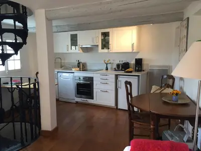 a kitchen with white cabinets and a dining room table at Campanina in Bonnieux