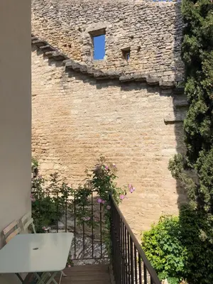 a brick wall with a window on a balcony at Campanina in Bonnieux