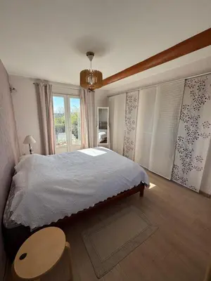 a bedroom with a bed and a table and a window at Mas de charme provencal in Cavaillon