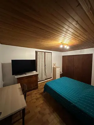 a bedroom with a bed and a flat screen tv at Maison Provençale Vue Étang & Charme Médiéval in Saint-Chamas