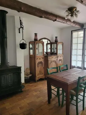 a dining room with a table and a wood stove at Maison Provençale Vue Étang & Charme Médiéval in Saint-Chamas