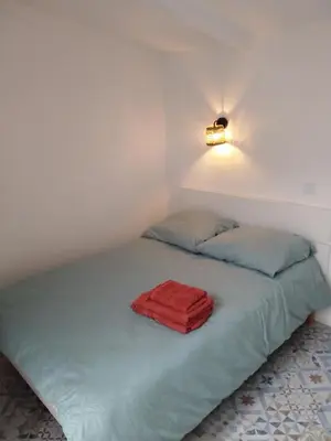 a bedroom with a bed with a red towel on it at Studio à la campagne in Éguilles