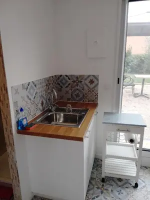 a small kitchen with a sink and a table at Studio à la campagne in Éguilles