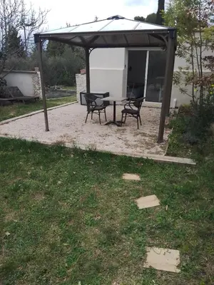 a picnic table and two chairs under a pavilion at Studio à la campagne in Éguilles