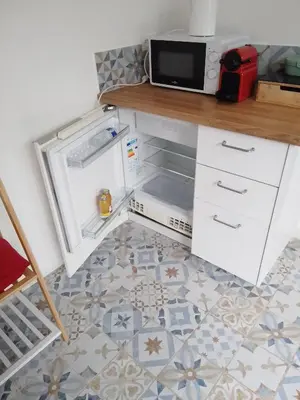 an open refrigerator with a microwave on top of it at Studio à la campagne in Éguilles