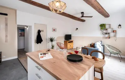a kitchen and living room with a table and chairs at Charmant Appartement au Cœur du Village de Bedoin in Bédoin