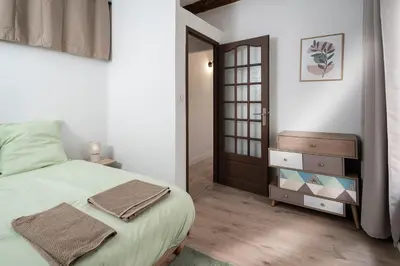 a bedroom with a large bed and a door at Charmant Appartement au Cœur du Village de Bedoin in Bédoin