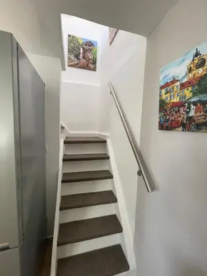 a staircase in a room with a painting on the wall at La l isloise in LʼIsle-sur-la-Sorgue
