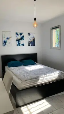 a bedroom with a large bed with blue pillows at Villa climatisée dans Domaine privé Aix en Provence in Aix-en-Provence