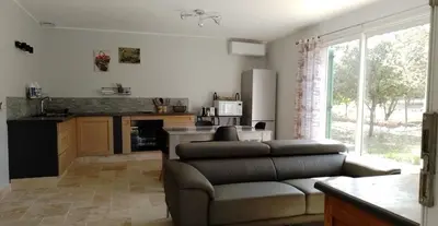a living room with a couch and a kitchen at Lou mazet in La Roque-sur-Pernes