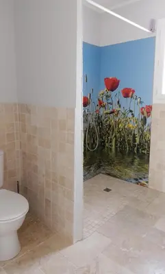 a bathroom with a toilet and a mural of flowers at Lou mazet in La Roque-sur-Pernes