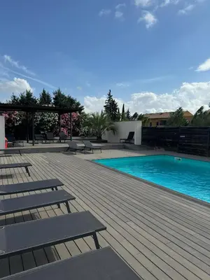 a swimming pool with benches and a wooden deck at 119 Sous le ciel de Provence - Aix in Éguilles