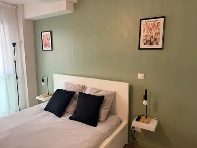 a bedroom with a bed with two black pillows at 119 Sous le ciel de Provence - Aix in Éguilles