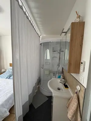 a bathroom with a sink and a toilet and a bed at Chez DOMI in LʼIsle-sur-la-Sorgue
