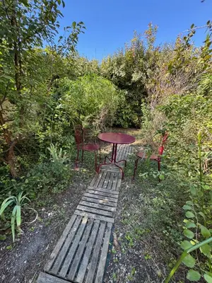 a picnic table and two chairs in a garden at Chez DOMI in LʼIsle-sur-la-Sorgue
