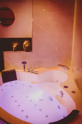 a bath tub in the middle of a room at Osez! Le fruit défendu Loveroom Carpentras in Carpentras