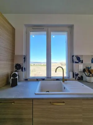 a kitchen with a sink and a large window at Lou Miradou in Maubec