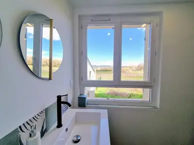 a bathroom with a mirror and a sink and a window at Lou Miradou in Maubec