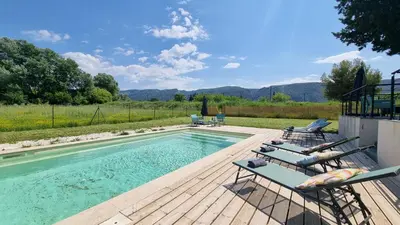 a swimming pool with two lounge chairs next to it at Lou Miradou in Maubec