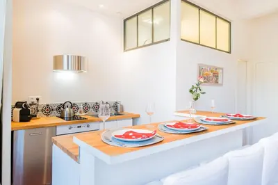 a kitchen with a table with plates and wine glasses at Gorgeous! heart of Aix en Provence appartement climatisé in Aix-en-Provence