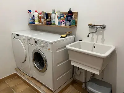 a bathroom with a washing machine and a sink at Le Mas de Quatremonts - Your refuge in Provence in Bonnieux