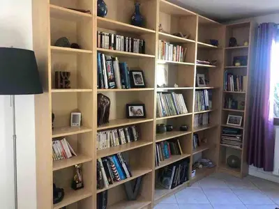 a library with wooden shelves filled with books at Maison provençale familiale avec piscine - 6 personnes in Lambesc