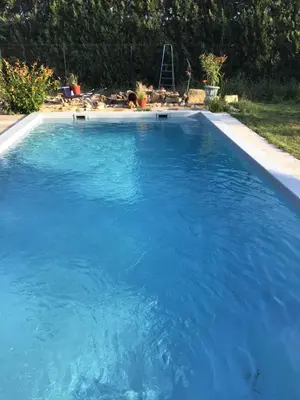 a large swimming pool with blue water in a yard at Gites victoria in Cavaillon