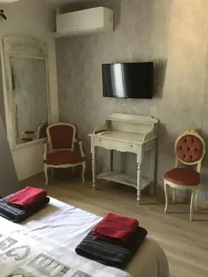 a bedroom with a bed and a desk and a piano at Gites victoria in Cavaillon
