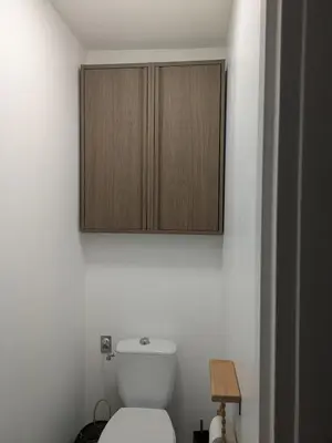 a bathroom with a toilet with wooden cabinets on the wall at charmante petite maison - piscine hors sol - proche Avignon in Avignon