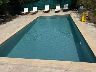 a swimming pool with chairs and blue water at Le Clos d'Aix Célony studio 9 parking in Aix-en-Provence
