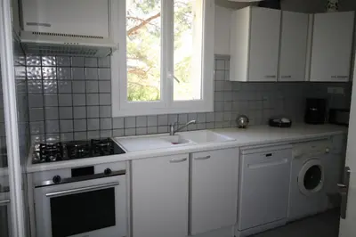 a white kitchen with a sink and a stove at Villa avec piscine dans le Luberon in La Tour-dʼAigues