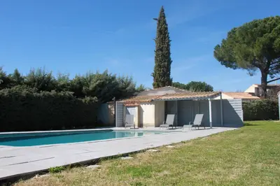 a swimming pool with two chairs and a house at Villa avec piscine dans le Luberon in La Tour-dʼAigues