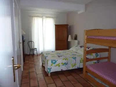 a bedroom with a bed and a bunk bed at Villa avec piscine dans le Luberon in La Tour-dʼAigues