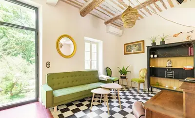 a living room with a green couch and a table at House By The Sorgue River With Private Access in Fontaine-de-Vaucluse