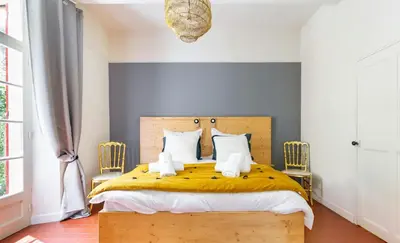 a bedroom with a yellow bed with two chairs at House By The Sorgue River With Private Access in Fontaine-de-Vaucluse