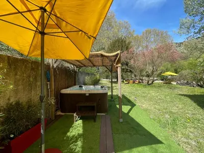 a large yellow umbrella and a tub in a yard at House By The Sorgue River With Private Access in Fontaine-de-Vaucluse