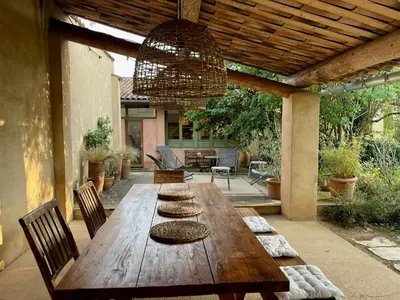 a wooden table on a patio with chairs and a ceiling at Bright Villa In The Heart Of Luberon in Céreste