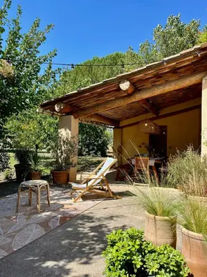 a patio with a wooden pergola and a chair at Bright Villa In The Heart Of Luberon in Céreste