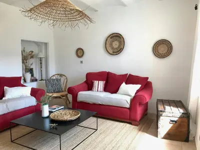 a living room with a red couch and a table at Historic Bastide With Private Pool In The Luberon in Céreste