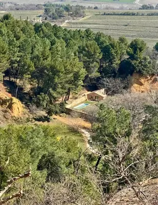 an aerial view of a house with a swimming pool in the forest at Bohemian House Overlooking Roussillon in Roussillon
