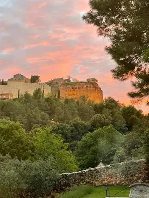 a castle on top of a hill with trees at Bohemian House Overlooking Roussillon in Roussillon