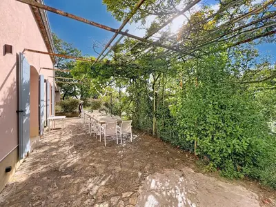 a patio with a table and chairs outside of a building at Grande maison de famille rénovée, vue sur Sainte Victoire in Venelles