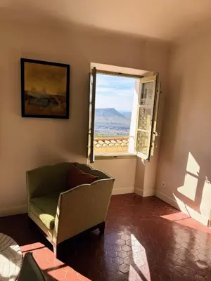 a living room with a chair and a window at Les Terrasses de Ventabren in Ventabren