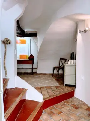 a living room with a white wall and a staircase at Les Terrasses de Ventabren in Ventabren