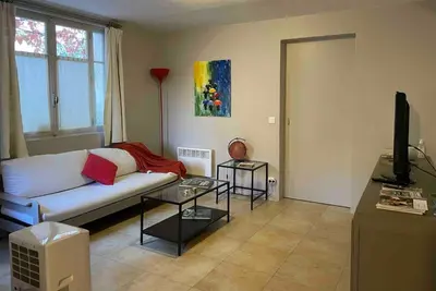 a living room with a white couch and a television at Appartement de charme au pied du château in Châteaurenard